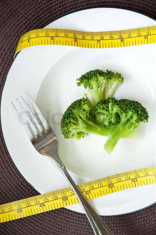 Fresh broccoli in white dish with measure tape around, stock photo