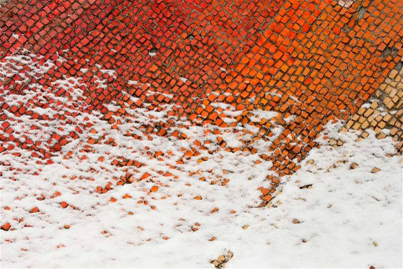A fragment of an old colored mosaics partially covered with snow. Beginning of winter, stock photo