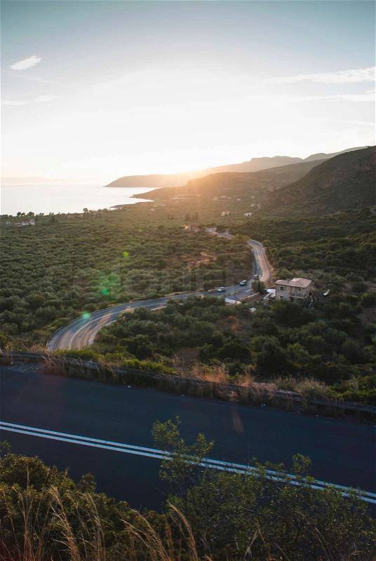 Mediterranean road on sunset. Cloudy sky. Greece, stock photo