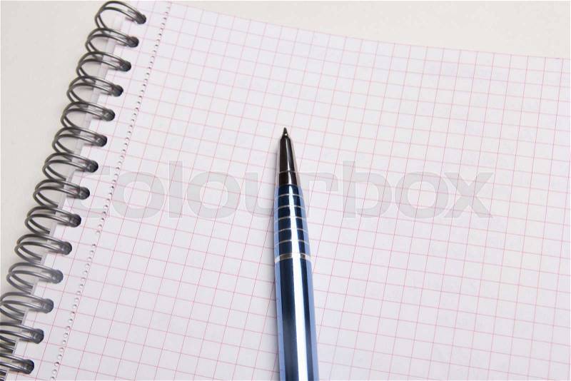 Close up of pen on blank note book with checked pages, stock photo