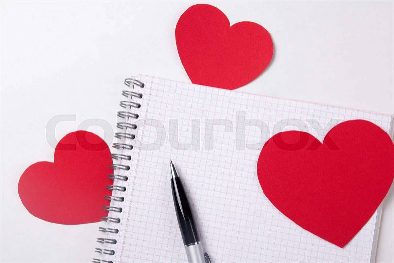 Love letter concept - note book with pen and red paper hearts, stock photo