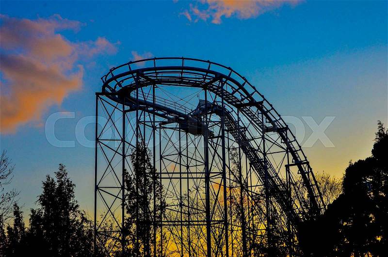Silhouette of a roller coaster at sunset, stock photo