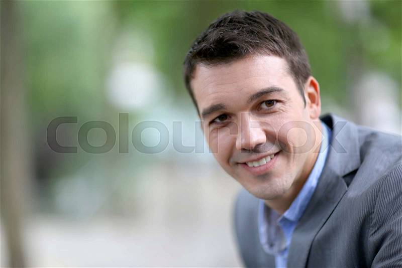 Portrait of handsome man with jacket standing in the street, stock photo