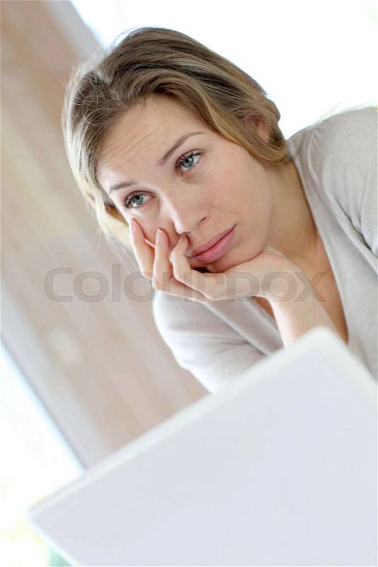 Active woman in front of laptop with upset look, stock photo