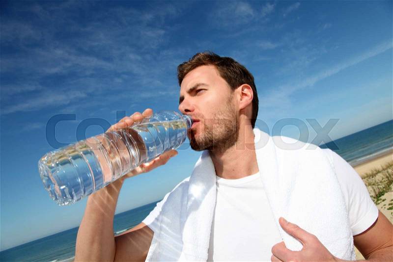 Portrait of jogger drinking water from bottle, stock photo