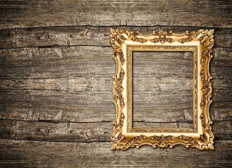 Baroque golden frame over rustic wooden background. Grungy texture, stock photo