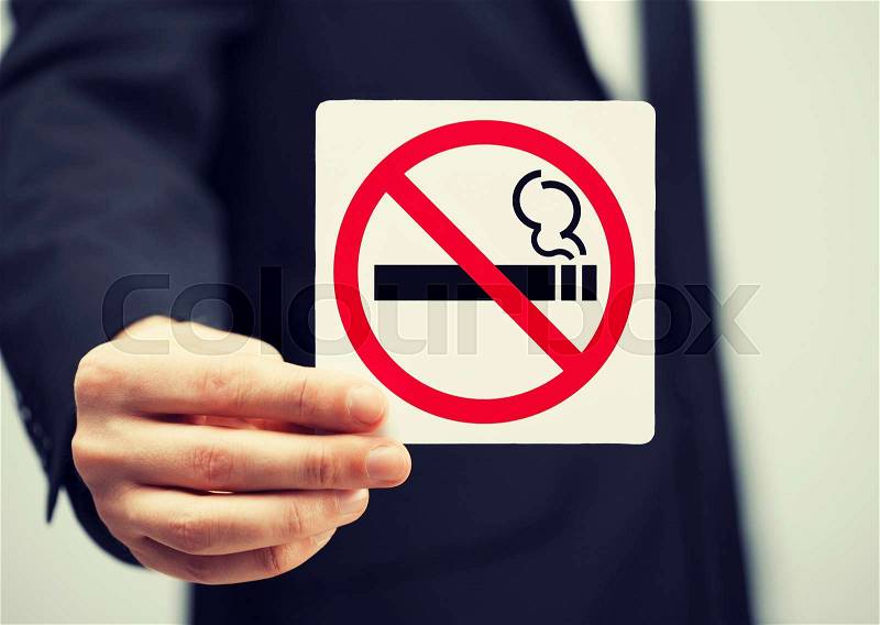 Picture of man in suit holding no smoking sign, stock photo