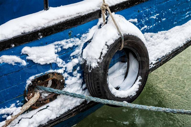 Fender on a fishing boat in a port in winter, stock photo