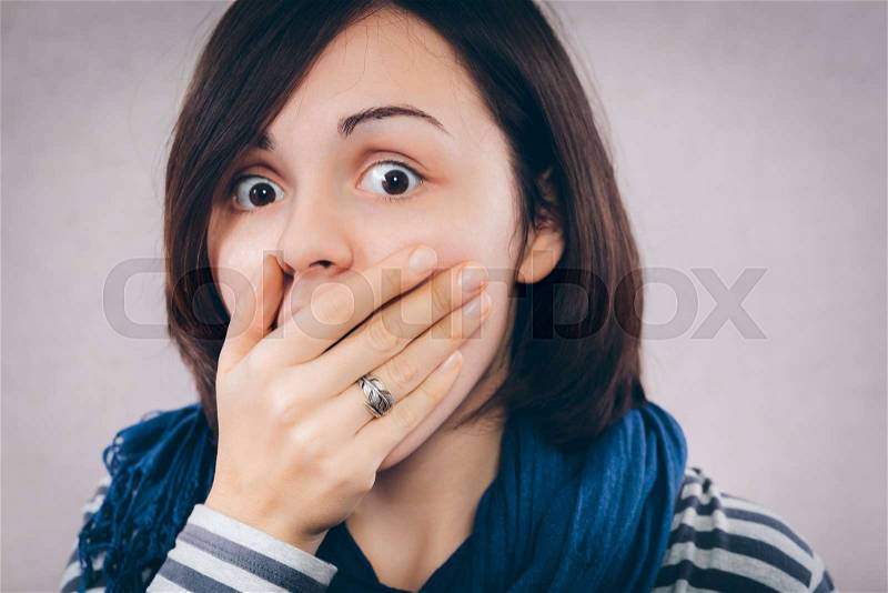 Surprised woman with hand over her opened mouth and big eyes, stock photo