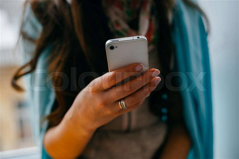 Young woman dials number on mobile phone, stock photo