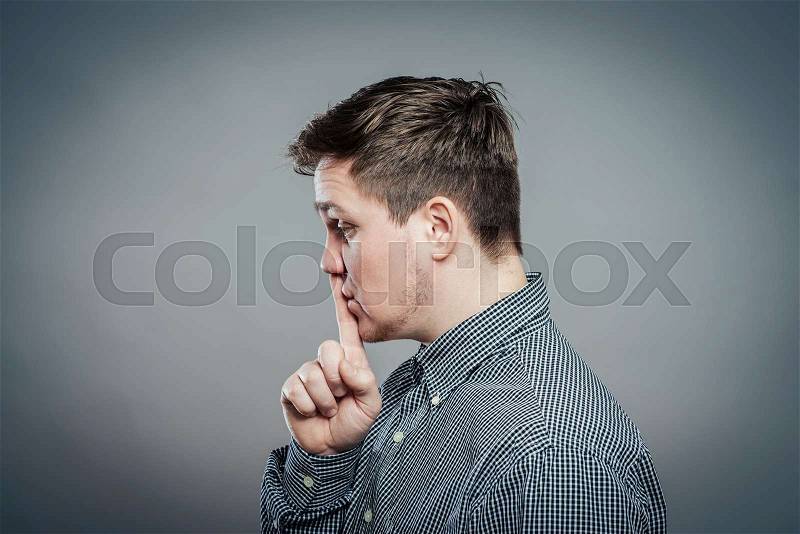 Young man making silence gesture, shhh!!, stock photo