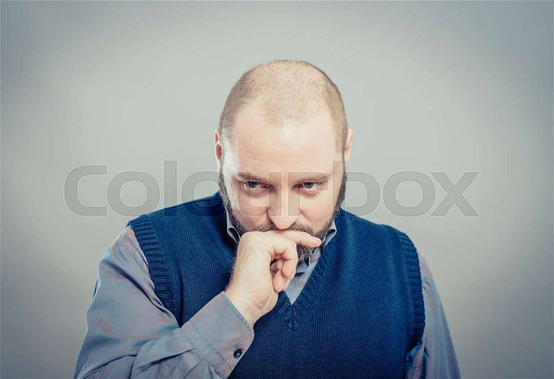 Young man thinking with hand on face, stock photo