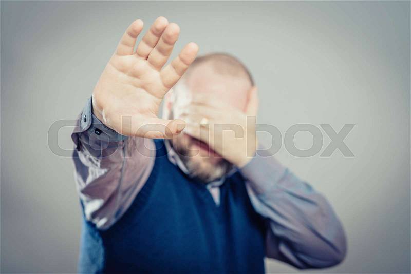 Young man laughing covering his face, stock photo