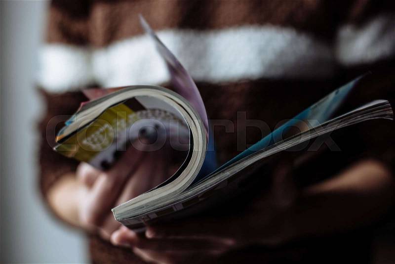 Portrait of young handsome guy holding a journal, stock photo