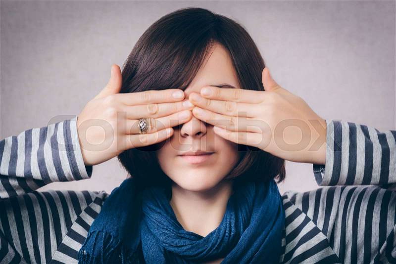 Woman covering her eyes, stock photo