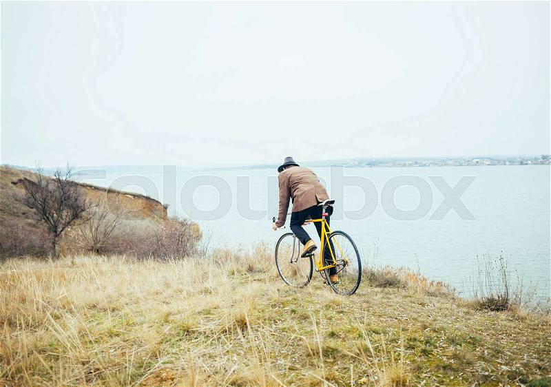 Person riding a bike downhill to the river, stock photo