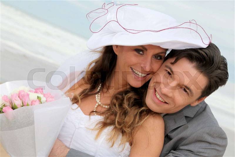 Portrait of happy married couple at the beach, stock photo