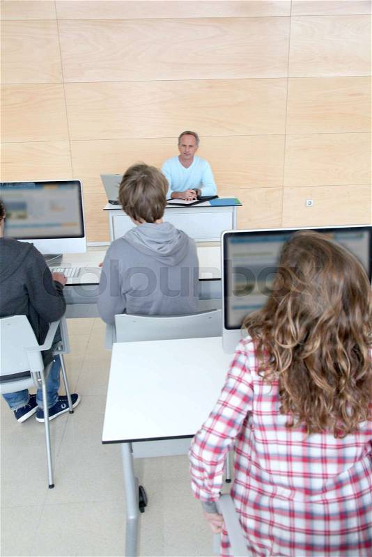 Teacher and students in classroom, stock photo