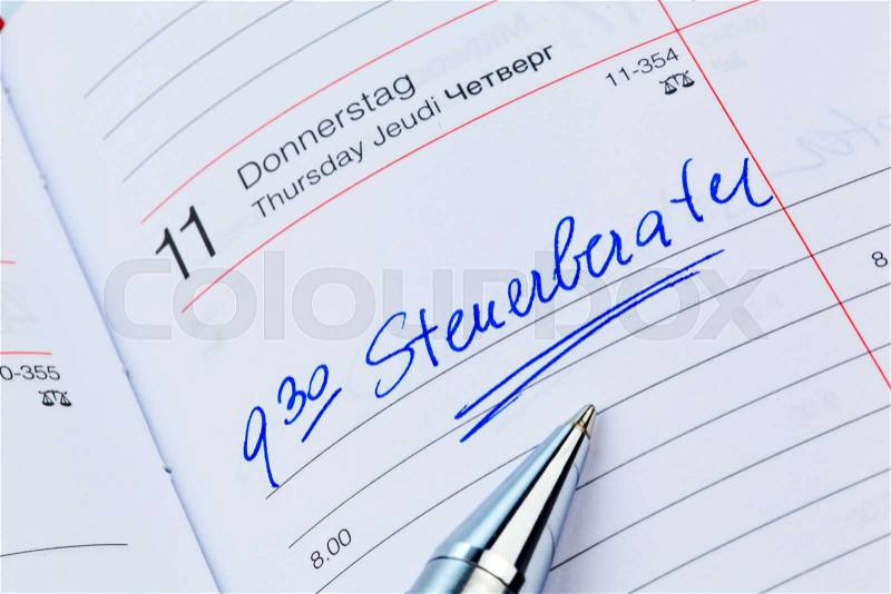 An appointment is entered on a calendar: tax services, stock photo