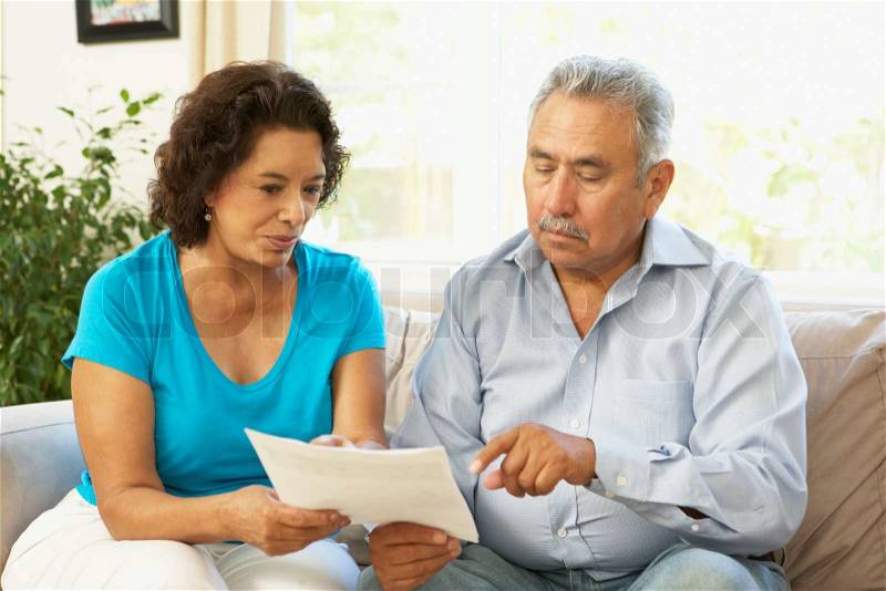 Senior Couple Studying Financial Document At Home, stock photo