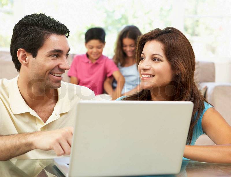 Parents Using Laptop At Home, stock photo