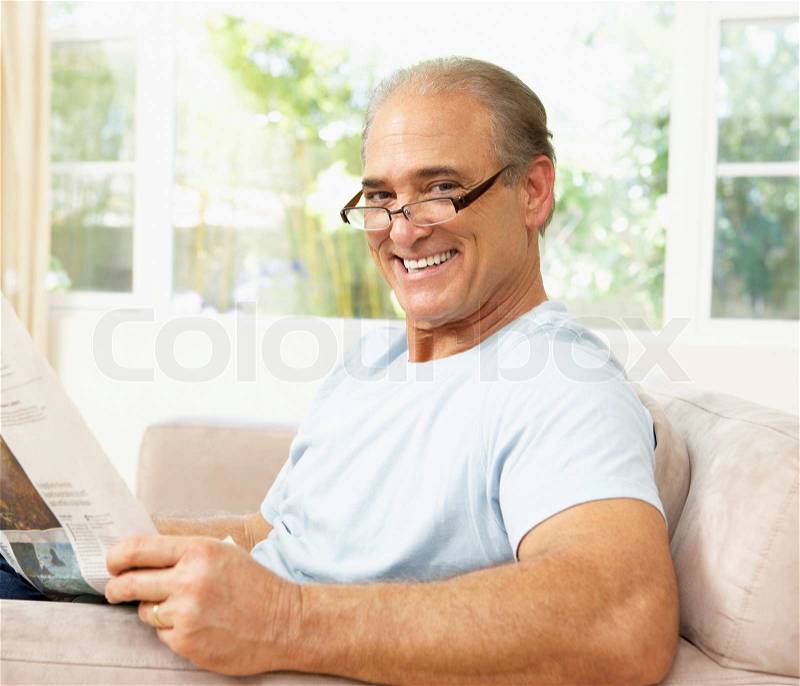 Senior Man Reading Newspaper At Home, stock photo