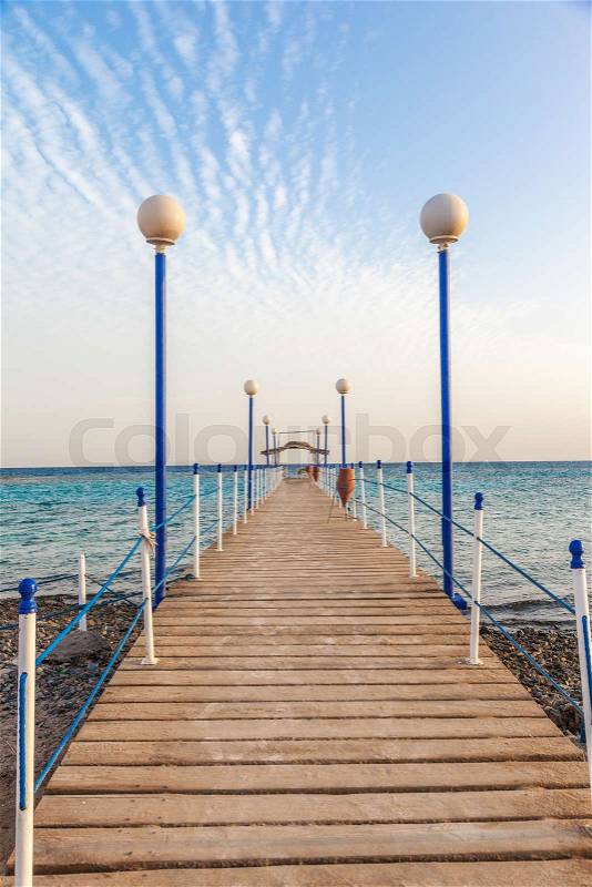 Wooden pier leading to open blue sea, stock photo