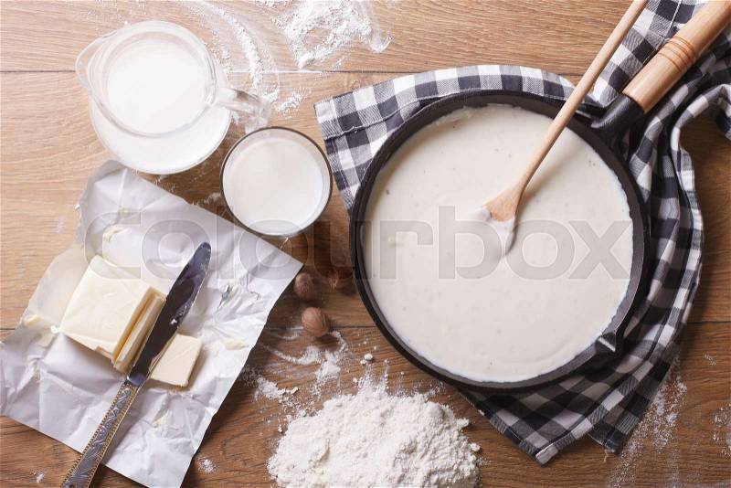Preparation of bechamel sauce in a pan and ingredients on the table. horizontal view from above , stock photo