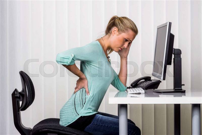 A woman sitting at a desk and has pain in her back. photo icon for proper posture at work in the office, stock photo