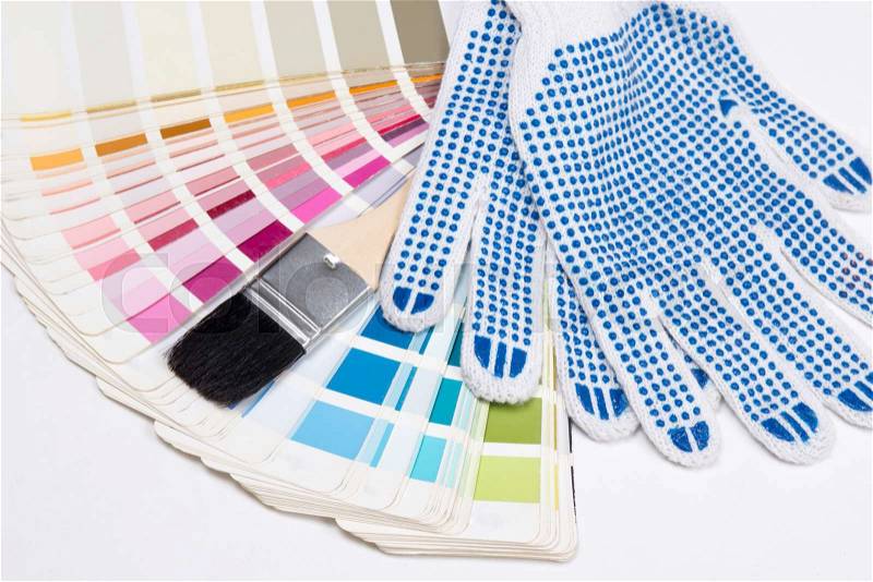 Close up of painter\'s tools - brush, work gloves and colorful palette over white background, stock photo