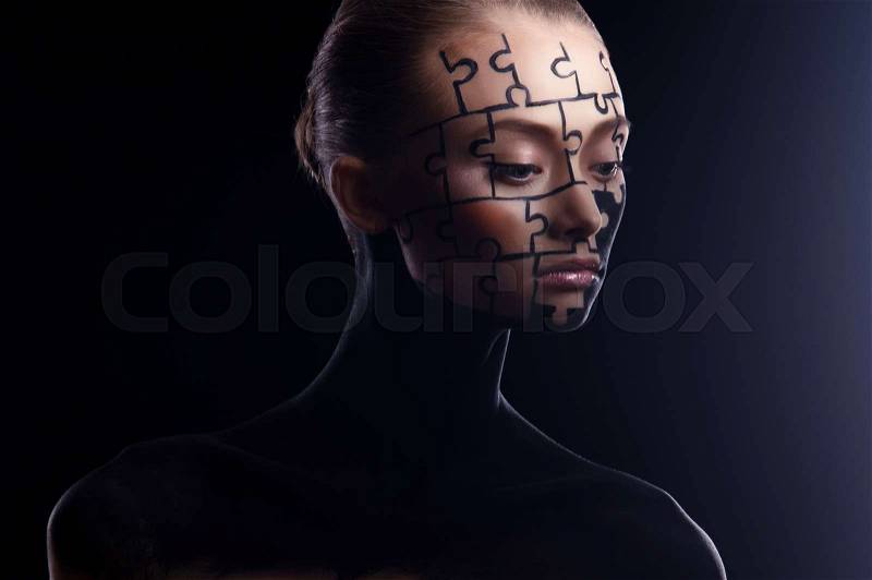 Puzzles painted on a beautiful woman\'s face, stock photo