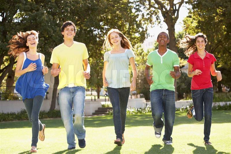 Group Of Teenagers Running Through Park, stock photo