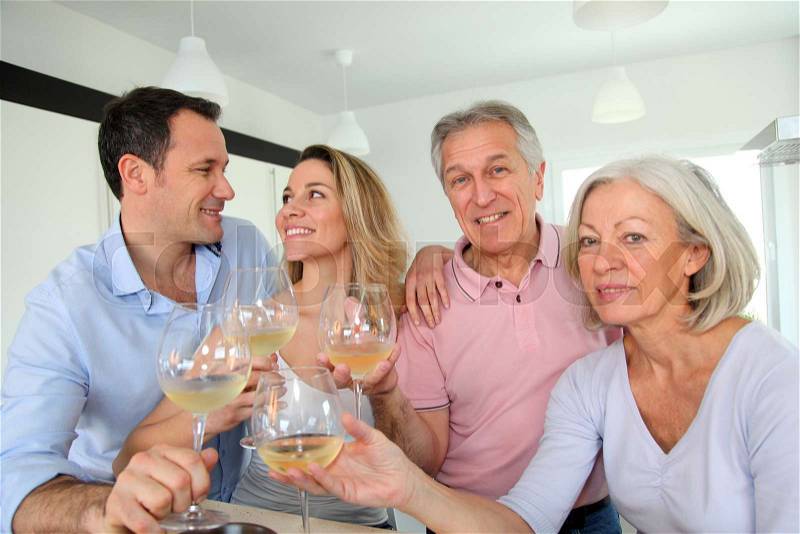 Family in home kitchen drinking wine, stock photo