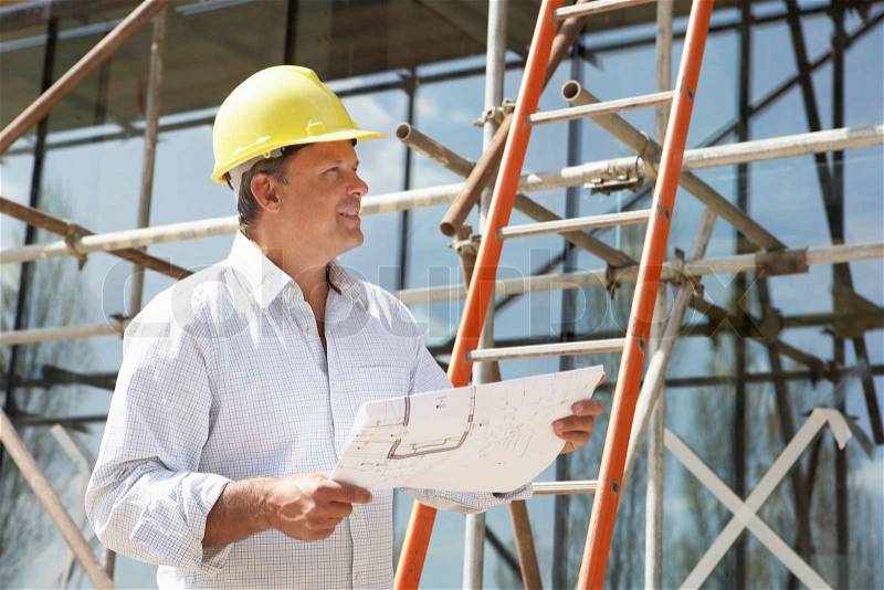 Architect Studying Plans Outside New Home, stock photo