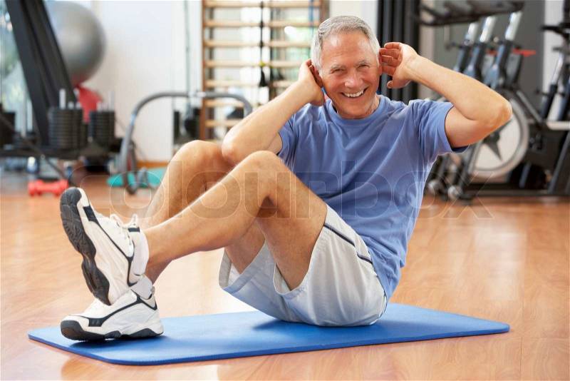Senior Man Doing Sit Ups In Gym, stock photo