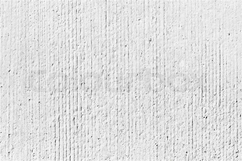 Rough white concrete wall background texture with vertical relief lines, stock photo