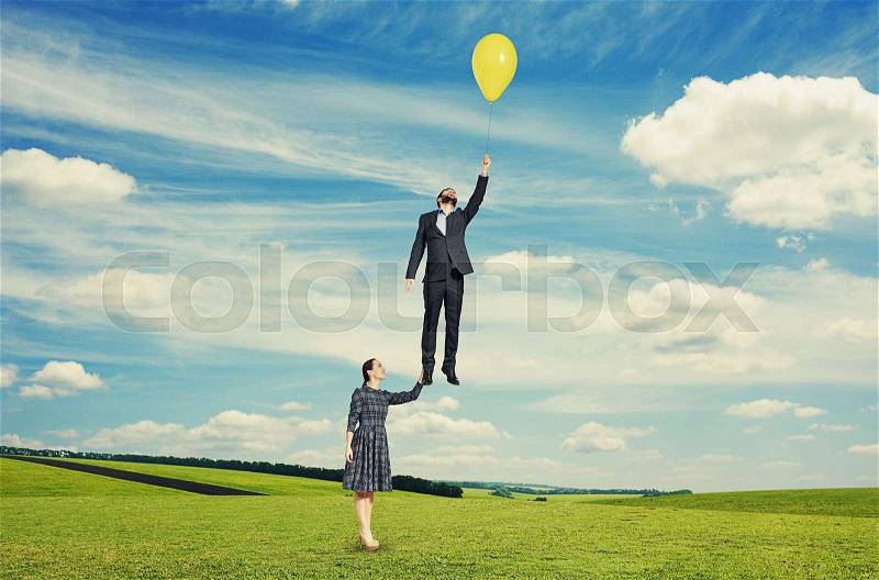 Young beautiful woman holding flying man. photo at outdoor, stock photo