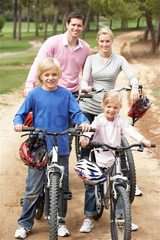 Family enjoying bike ride in park, stock photo