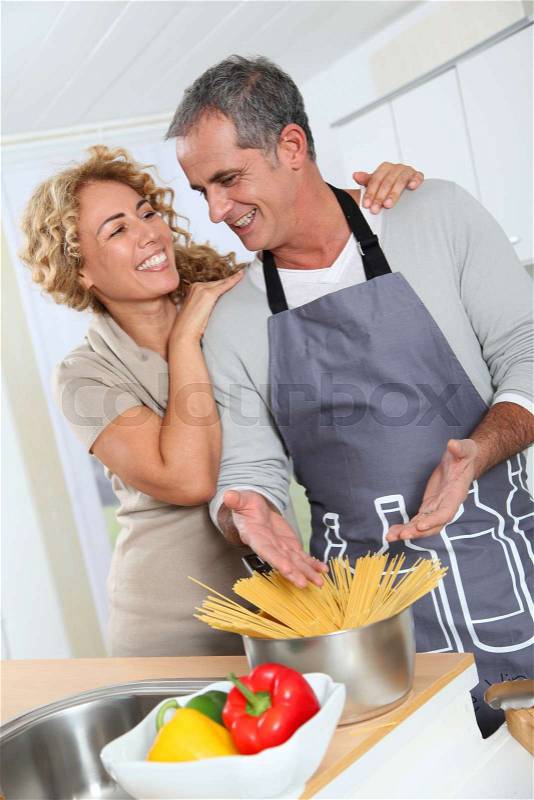 Happy couple preparing italian dinner at home, stock photo
