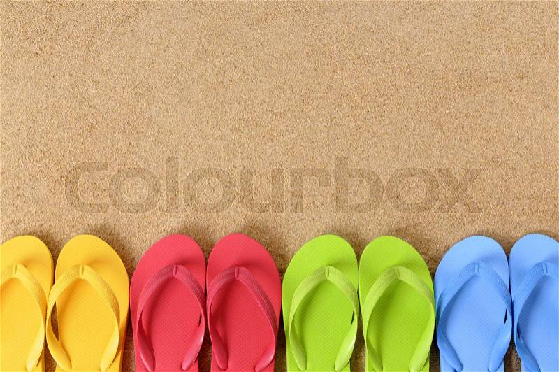 Flip flops in a row on a sandy beach. Space for copy, stock photo