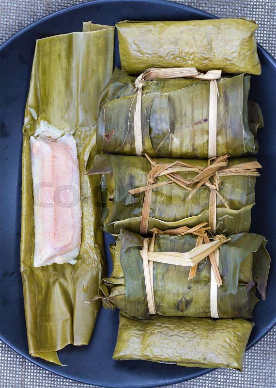 Glutinous rice with banana and peanut steamed in banana leaf - Thai traditional food, stock photo