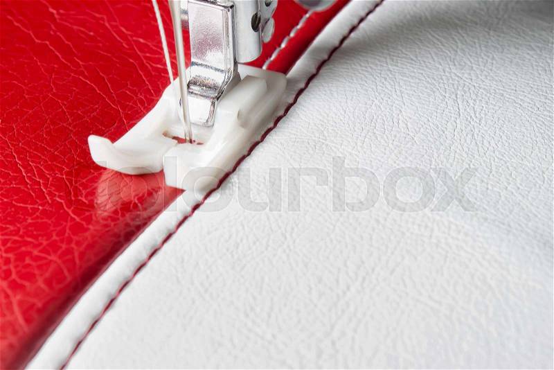 Sewing machine and white and red leather with a seam close-up, stock photo