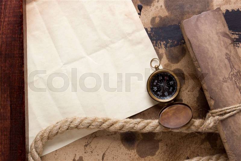 Roll of parchment with a compass and marine rope, stock photo