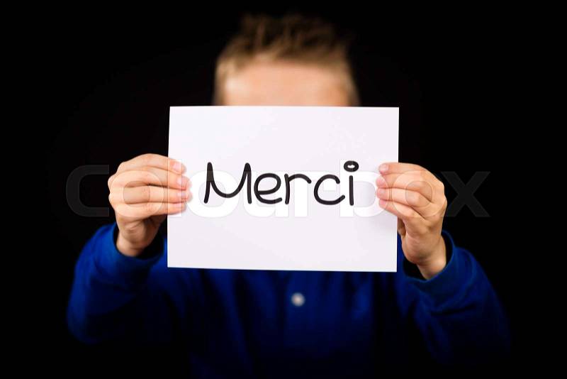 Studio shot of child holding a sign with French word Merci - Thank You, stock photo