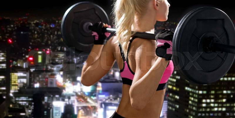 Fitness, sport and dieting concept - sporty woman exercising with barbell from back, stock photo