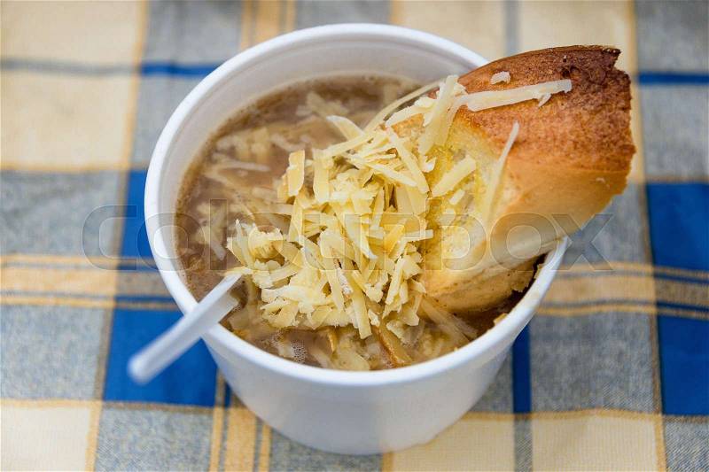 Onion soup with cheese and bread, street food in plastic ware, stock photo