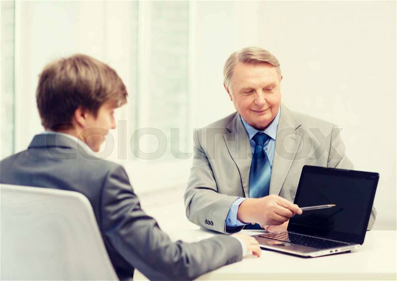 Business, advertisement, technology and office concept - older man and young man with laptop computer in office, stock photo