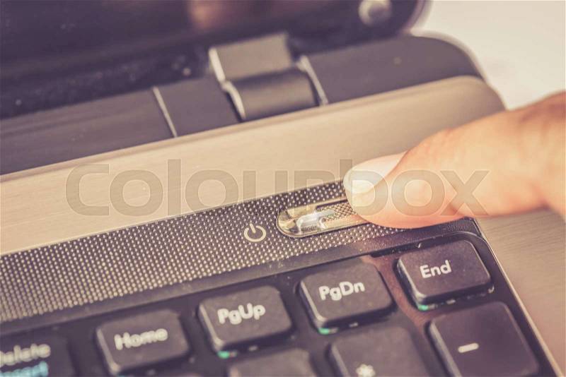 Close up finger press power off button on laptop, stock photo