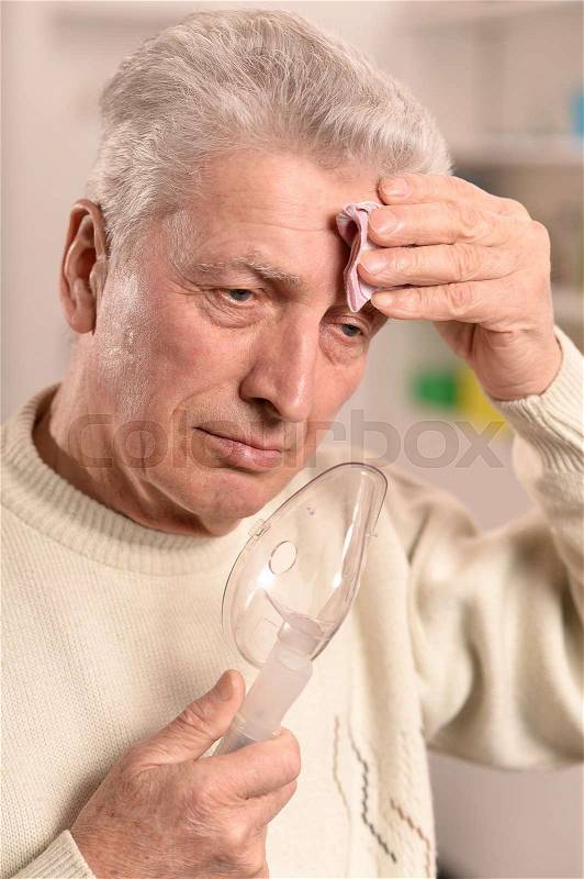Close-up portrait of an elder man making inhalation, stock photo