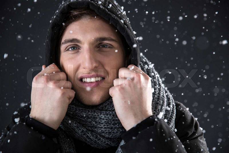 Happy man in winter cloth with snow on background, stock photo